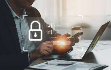 İş adamı cep telefonu ve dizüstü bilgisayarı kullanarak erişim, bilgi güvenliği ve şifreleme, güvenli erişim kullanıcısının kişisel bilgileri, internet erişimi, siber güvenlik. Siber güvenlik teknolojisi kavramı.
