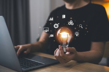 İş kadını elinde ampulle mezuniyet şapkasını, eğitim ikonlarını ve dizüstü bilgisayarını gösteriyor. E-öğrenim web kursları konsepti. Çevrimiçi sınıf kavramını öğrenme fikri