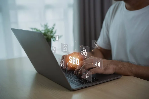 Search engine optimize. Man woking on laptop on virtual screen with SEO icon for analysis SEO Search Engine optimizing your website traffic to rank in search engines SEO. Promoting ranking.