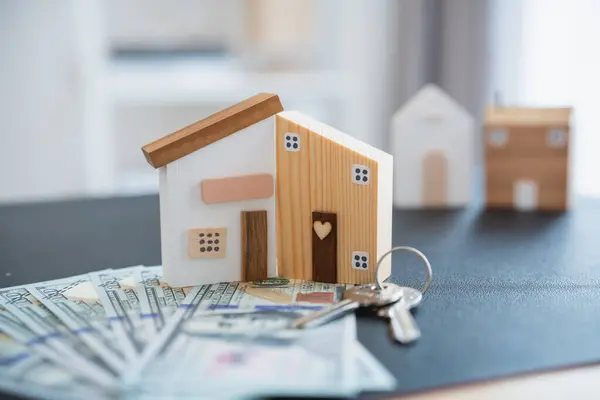 Home loan concept. House model on a table as a real estate agent and customer discuss contracts for buying, insuring, financing the property. Loan finance economy commercial real estate investments.