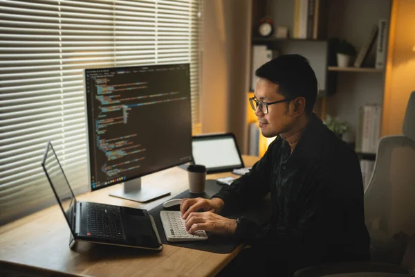 Software develper asian man wearing glasses working coding Write a program develope AI application on laptop at home office. Programmer working develop web application. Software programming concept.