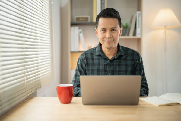 Asian freelance business man smiling working talking making video call in home office, using laptop, talking, watching webinar or studying language, speaking, online training, explaining, e-learning.