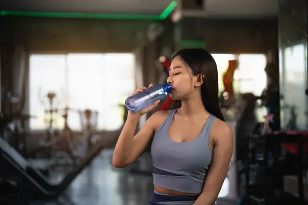 Happy Asian sport athlete women exercise drink water and resting after exercise and workout smile training at the gym. athlete girl training strong and good health and strength. Sport health concept.