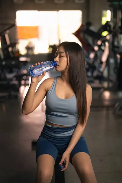 Happy Asian sport athlete women exercise drink water and resting after exercise and workout smile training at the gym. athlete girl training strong and good health and strength. Sport health concept.