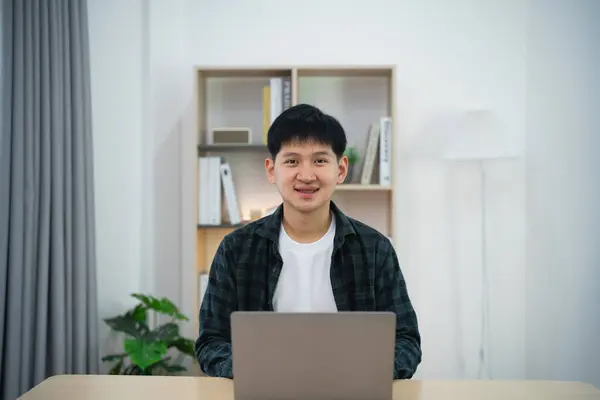 Smart Asian man with braces smiling working with computer laptop. concept work form home, stay at home. freelance life style, New normal social distancing lifestyle. Work form anywhere concept.