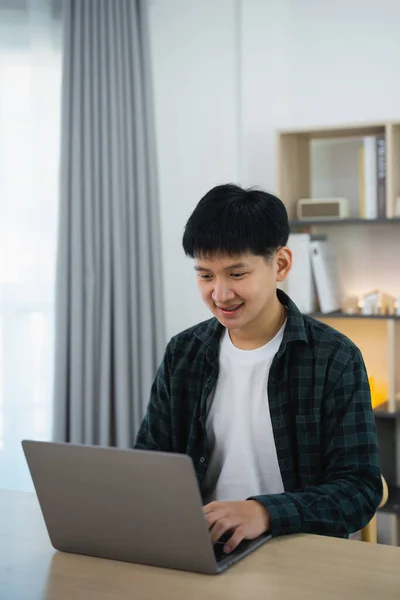 Smart Asian man with braces smiling working with computer laptop. concept work form home, stay at home. freelance life style, New normal social distancing lifestyle. Work form anywhere concept.