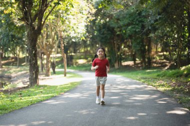 Mutlu Asyalı kız bebek gülümsüyor. Küçük kız gün batımında koşuyor ve gülümsüyor mutlu kız bebek gülümsüyor. Gün batımında koşan küçük bebek. Oyun bahçesinde koşan sevimli bebek..