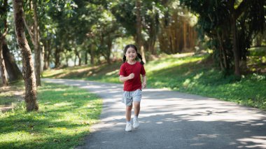 Mutlu Asyalı kız bebek gülümsüyor. Küçük kız gün batımında koşuyor ve gülümsüyor mutlu kız bebek gülümsüyor. Gün batımında koşan küçük bebek. Oyun bahçesinde koşan sevimli bebek..