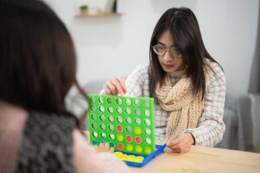 Genç kadınlar ev ortamında oyun oynarken strateji ve beceri oyunundan zevk alıyorlar.