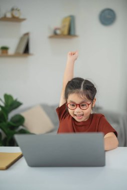 Heyecanlı Çocuk Arkaplanda Bitkiler ve Raflarla Dolu Kapalı Salonda Dizüstü bilgisayar Kullanırken Başarı Kutlaması