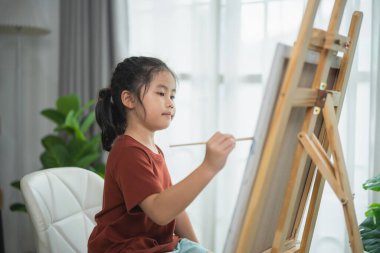 Genç Kız, Evinde Ahşap Paskalya ve Çağdaş ve Parlak İç Dekorasyonda Yeşillik Bitkileriyle Yaratıcılığa Odaklandı