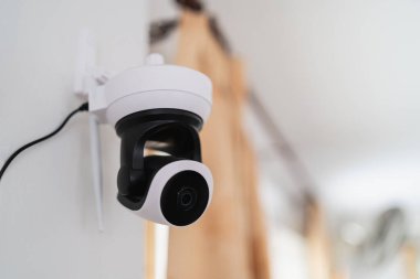 Çağdaş iç tasarımda ev veya ofis güvenliği ve güvenliği için izleme ve izleme sağlayan bir duvara yerleştirilmiş kapalı güvenlik kamerası.