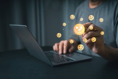 Yakın plan iş adamı eli, Yüzen Emoji Yüzleri Dizüstü Bilgisayarı ile Modern Çalışma Alanında Duyguları, Mutluluğu, Üzüntüyü ve Daha fazlasını Temsil Ediyor