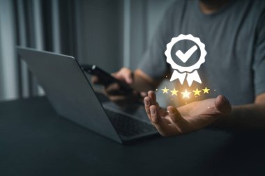 Yakın plan iş adamı Laptop ve Smartphone kullanarak Dijital Başarı 'yı Yıldızlar, Denetimler ve Ödül Simgesi Başarı ve Kalite Güvencesi ile Sembolize ediyor