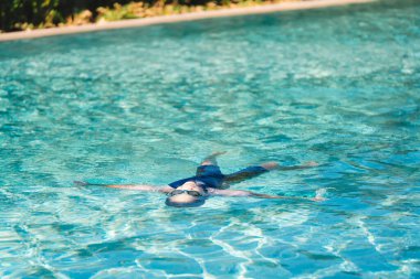 Parlak Güneş Işığı Altında Havuzda Yüzme, Su Dalgalanmaları ile Huzurlu Sahne, Huzur Arayan Kişiler İçin Yaz Tatil Etkinliği