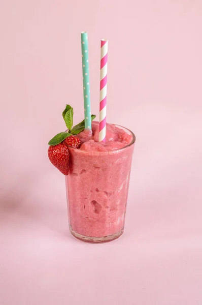 草莓软糖在一个杯子里 用稻草和草莓在粉红色的背景和自然光 垂直照片 — 图库照片