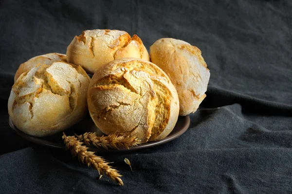 暗いテーブルクロスの背景に小麦の大規模なパンを閉じます コピースペース付きの選択的フォーカス — ストック写真