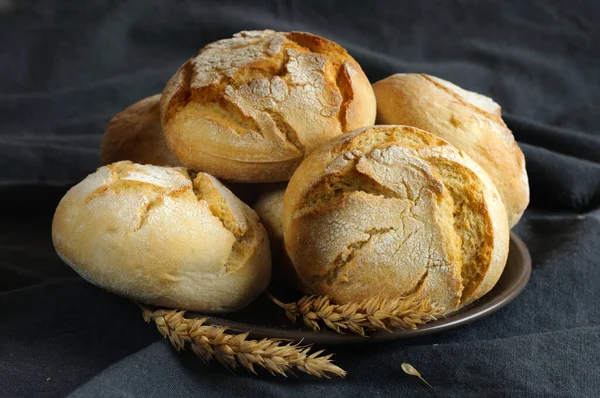 暗いテーブルクロスに対して小麦の大規模なパンのクローズアップ選択的な焦点と自然光 — ストック写真