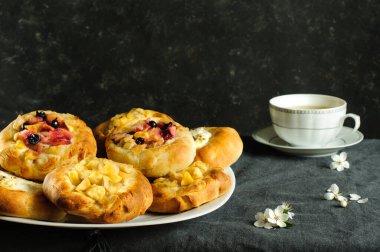 Elmalı ve süzme peynirli sıcak ev yapımı çöreklerin esmer bir duvara yapıştırılmış gerçek fotoğrafı. Doğal ışık, kopyalama alanı ile seçici odak