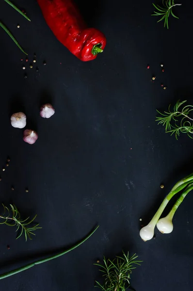 Frame of vegetables on a black vintage background with space for text in the center. Natural light, selective focus, top view. vertical image