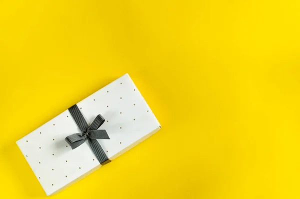 Gift white flat box on a yellow background. Wedding Day, ,Birthday, Women\'s Day, Mother\'s Day, Father\'s Day. Top view, selective focus flat lay, natural light. copy space