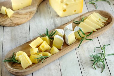 Çeşitli peynir parçaları, çeşitlilik ve yakın plan çekimler. Yüksek açı görünümü, doğal ışık, seçici odak