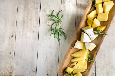 Tahta tabakta çeşitli peynirler. Kopyalama alanı olan üst görünüm