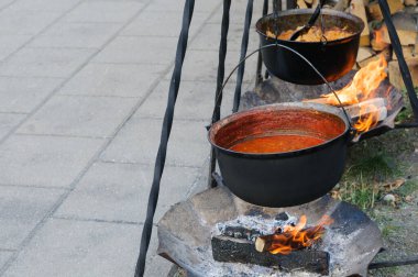 Açık ateşte kırmızı baharatlı gulaş çorbası ile sokak yemeği kazanı. Metin için yer