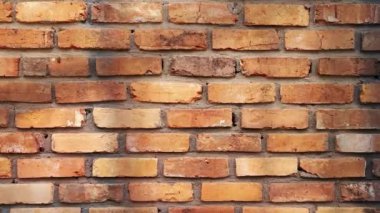 Eski bir kırmızı tuğladan yapılmış eski bir video eskimiş tuğlaların eskimiş dokusunu ve zamansız güzelliğini, zengin renkler ve karakterleri, nostalji ve tarihi anımsatıyor.