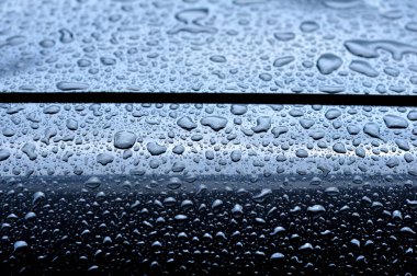 Araba gövdesine yapışan yağmur damlaları seçici odak noktası