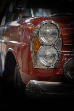 Headlight and hood of the old red car.