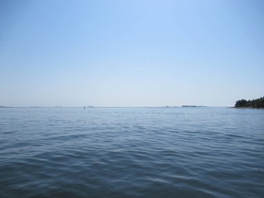 Blue sea and sky with small waves an islands on the horizon