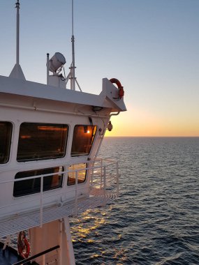 Sunset seen through a ship bridge at sea