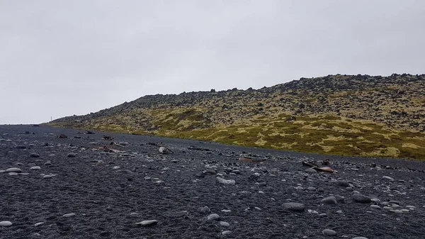 Lava field, black sand, rocks and ship wreck remains in Iceland