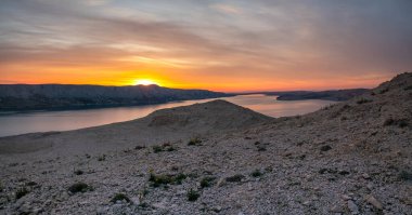Hırvatistan 'ın Pag adasının engebeli ve kayalık manzarası güzel bir gün batımında sergilendi