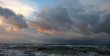 Panorama of storm clouds over the sea during sunset