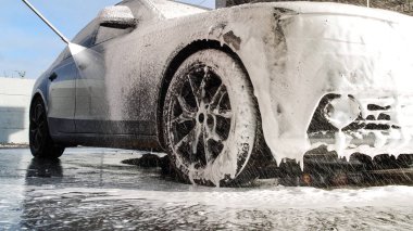 Dokunulmaz bir oto yıkamada lüks araba yıkamak. Köpüklü ve yüksek basınçlı su basınçlı sedan araba yıkıyorum. Araba yıkamada bahar temizliği..