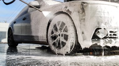 Dokunulmaz bir oto yıkamada lüks araba yıkamak. Köpüklü ve yüksek basınçlı su basınçlı sedan araba yıkıyorum. Araba yıkamada bahar temizliği..