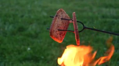 Doğada kamp ateşi. Kamp ateşinde ekmek kızartıyorum. Sıcak bir yaz akşamında kamp alanında şenlik ateşi.. 