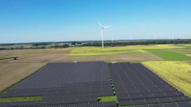 Güneş çiftliği ve rüzgar türbinleri hava manzaralı. Güneş enerjisi panelleri, fotovoltaik ve rüzgar çiftliği. Ekin yakınında güneş enerjisi santrali. Sürdürülebilir kaynaklar ve alternatif elektrik kavramı