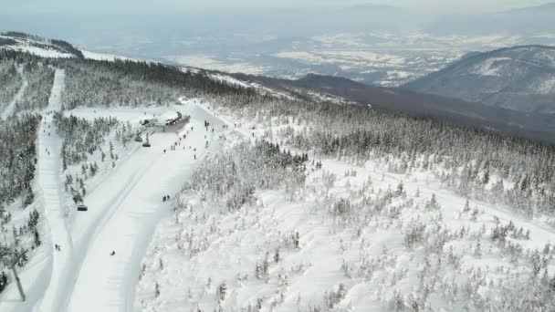 滑雪胜地 壮观的山地全景 空中风景 滑雪者和滑雪者滑下斜坡 美丽的滑雪胜地 配有滑雪电梯 冬季景观 还有新鲜的白雪 — 图库视频影像