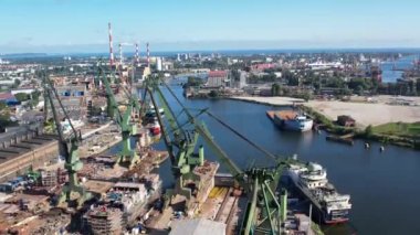 Tersane vinçleri hava manzaralı. Gdansk, Polonya, Avrupa 'daki Baltık Denizi kıyısında bir tersane çekimi. Endüstriyel sahil manzarası, liman ve kuru rıhtımda gemiler.