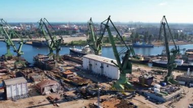 Tersane vinçleri hava manzaralı. Gdansk, Polonya, Avrupa 'daki Baltık Denizi kıyısında bir tersane çekimi. Endüstriyel sahil manzarası, liman ve kuru rıhtımda gemiler.