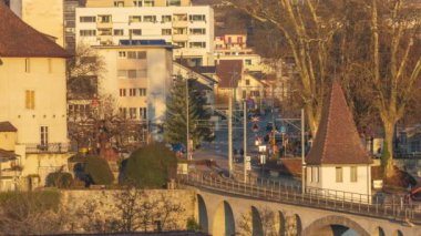 Zaman aşımlı arabalar, tramvaylar, otobüsler ve gün batımında insanlar. Trafiğin en yoğun olduğu saatte şehir ulaşımı. Bremgarten, İsviçre.