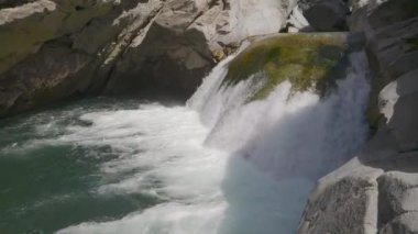 Dağlardaki kayalar arasında küçük bir şelalenin görüntüsü. Islak kaya ve taşların arasından akan sular.
