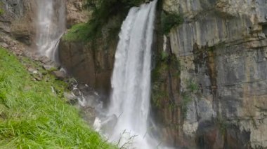 Dağlarda şelale. Dağların yükseklerindeki kayalardan su düşüyor. Seerenbach Şelalesi, Betlis, Amden, Walensee. St. Gallen, İsviçre Kantonu.