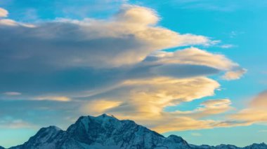 Dağların tepesinde dans eden bulutların hızlanması. Kış boyunca Alp dağlarında gün batımı. Bettmeralp 'ten görüntü. Valais Kantonu. İsviçre.