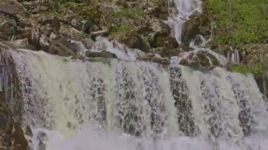 Dağlarda şelale. Düşen su yaklaşıyor. Şelaleden su damlıyor. Naefels yakınlarındaki Rauti şelalesi, Kanton Glarus, İsviçre.