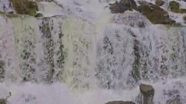 Dağlarda şelale. Düşen su yaklaşıyor. Şelaleden su damlıyor. Naefels yakınlarındaki Rauti şelalesi, Kanton Glarus, İsviçre.