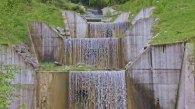 Şelaleden dökülen su. Nehirdeki taşların etrafında su akıyor. Beckenried yakınlarındaki Traeschlibach, Canton Nidwalden, İsviçre.